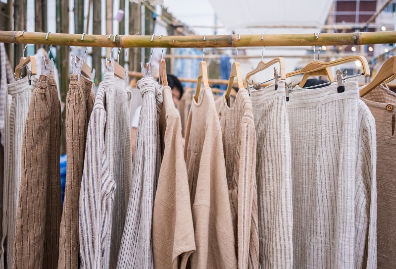 Fashionable clothes on hangers in a hand made market.